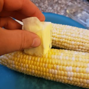 Using a stick of butter to butter corn