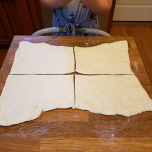 Pillsbury Pizza Dough cut into squares on a floured butcher block