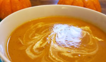 Butternut squash soup with pumpkins behind