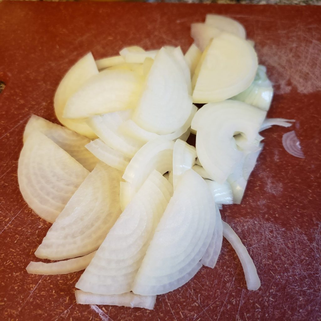 chopped onions on a red cutting board for southwest sheepherders breakfast