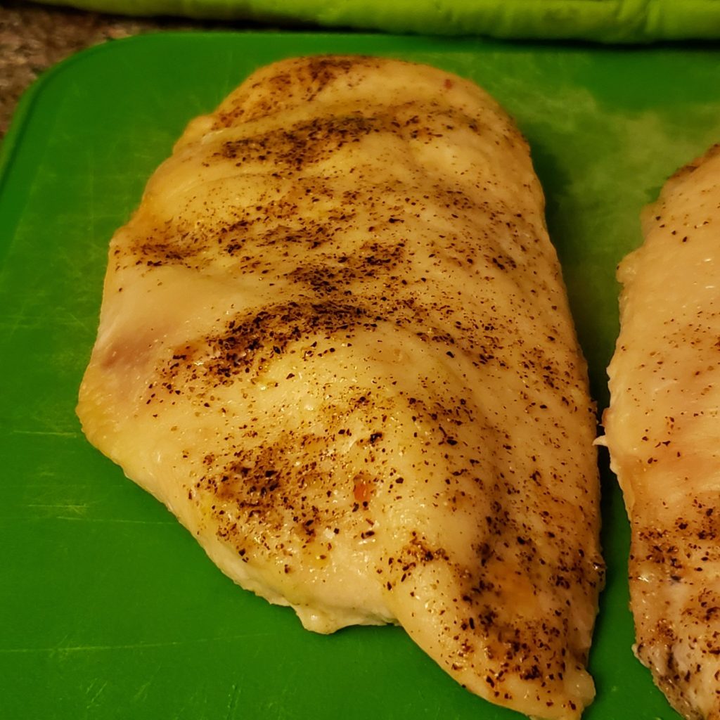 perfectly roasted chicken breast on a green cutting board for shepherd's pie