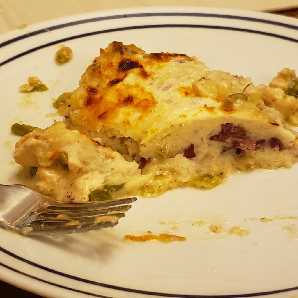 Slice of Chicken Shepherd's Pie on a white plate with a fork