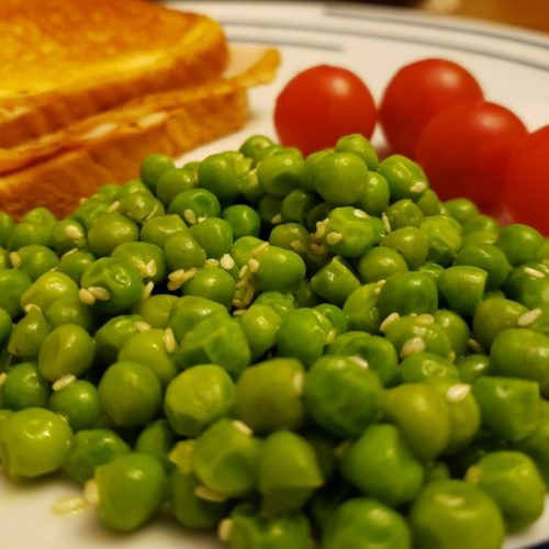 Ramen Peas on a plate with a sandwich and cherry tomatoes