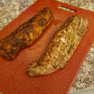 Two Perfectly Cooked Pork tenderloins on a red cutting board