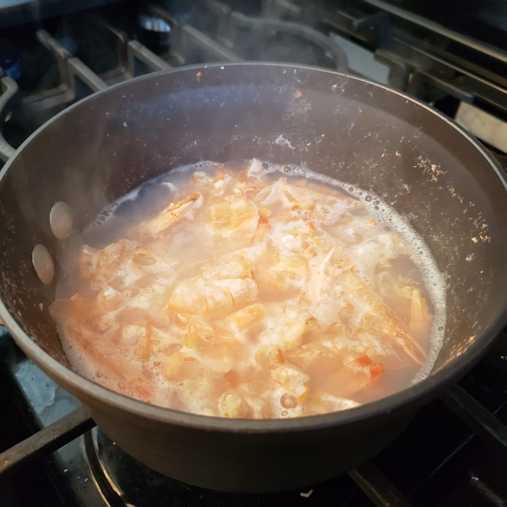 Boiled shrimp stock in a pot, shells still in the liquid