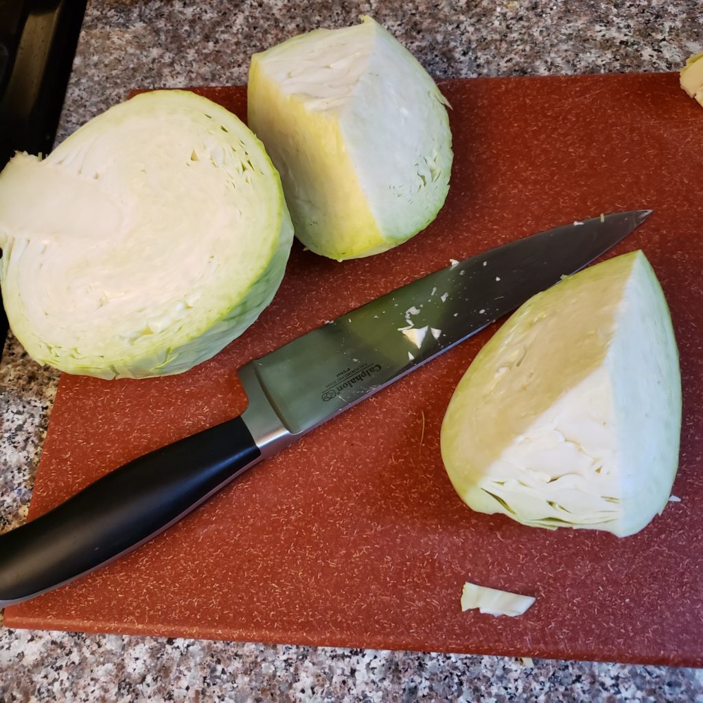 Cabbage halves on a red cutting board