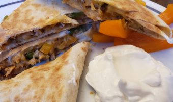 quesadilla dinner on a plate with sour cream