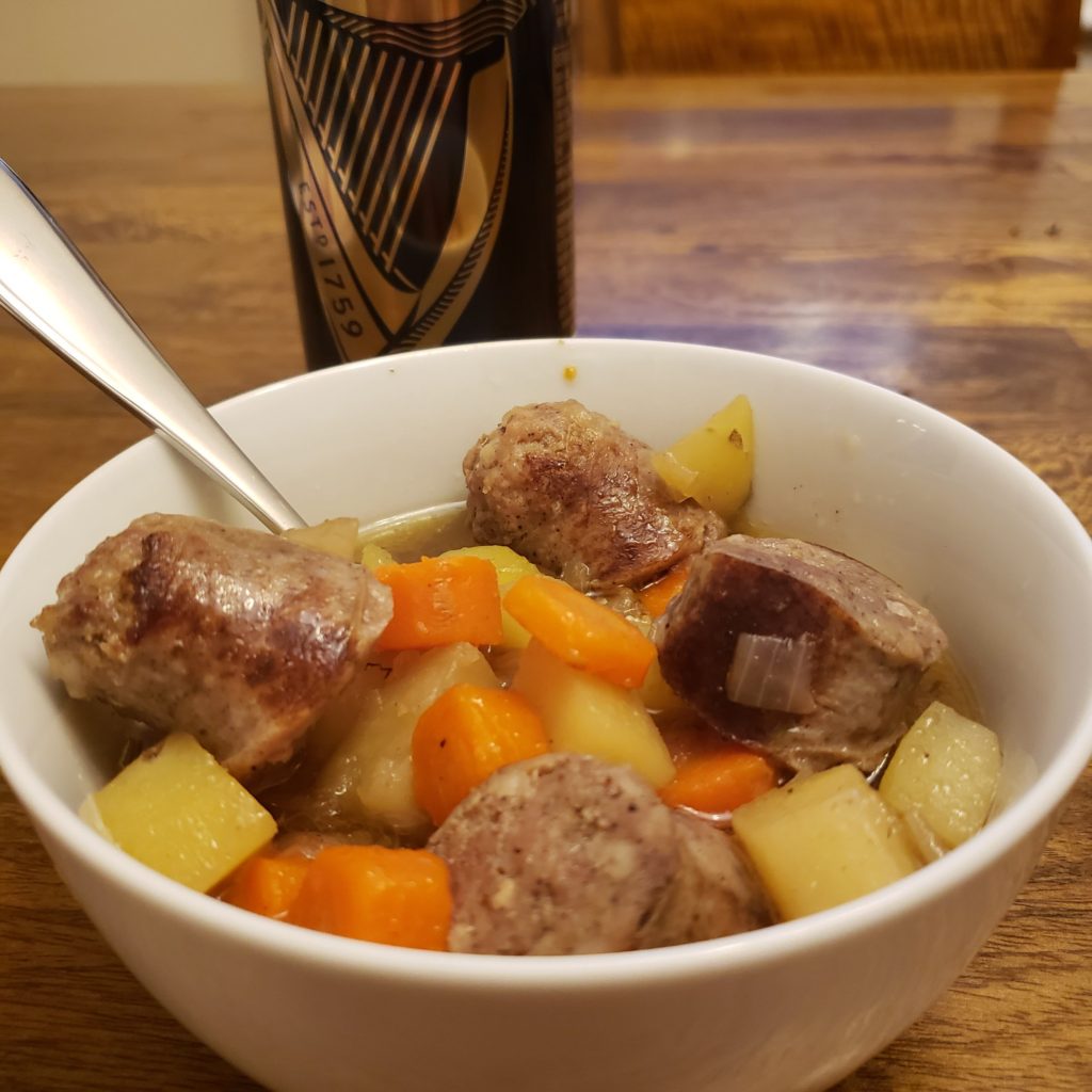 Dublin Coddle in a bowl, served with a can of guiness